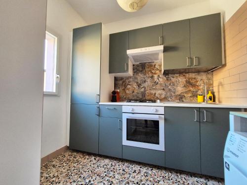 a kitchen with blue cabinets and an oven at La casa di Athina in Celano