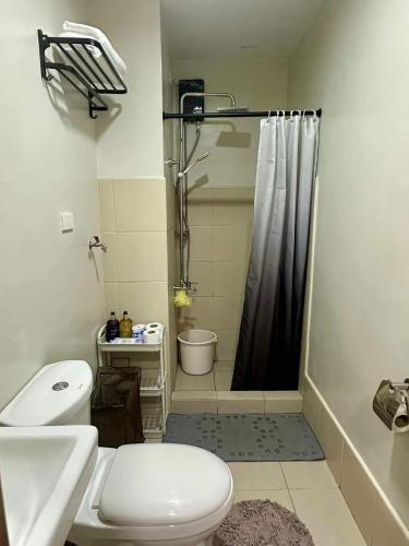 a bathroom with a shower and a toilet and a sink at SMDC CHARM 1 bedroom condo with Netflix & Balcony in Manila