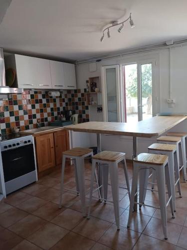 - une cuisine avec une grande table et des tabourets dans l'établissement Mas la Daune, à Le Cailar