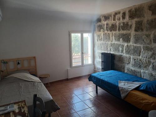 une chambre avec un lit et un mur en pierre dans l'établissement Mas la Daune, à Le Cailar