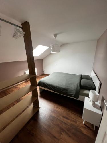 a small bedroom with a bed and a staircase at Jolie petite maison in Saint-Vaast