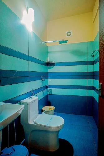 a blue and white bathroom with a toilet and a sink at Falcon Riverview Resorts in Kuttampuzha