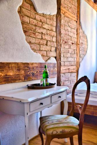a white desk with a bottle and a chair at Hotel & Café Mohrenbrunnen in Eisenberg
