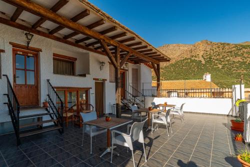 a patio with tables and chairs on a roof at Hotel La Fragua I in Trevélez