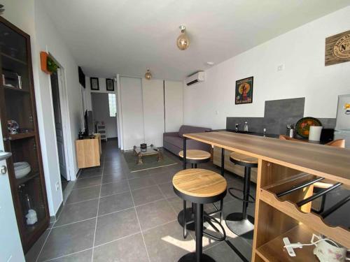- une cuisine et un salon avec un comptoir et des tabourets dans l'établissement Appartement - Le Seven, à Uzès
