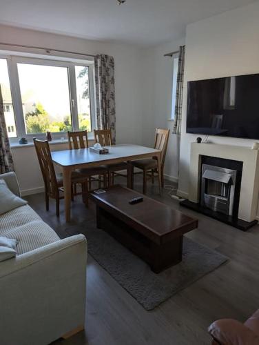a living room with a table and a fireplace at Lovely 3-Bed Edinburgh Flat in Edinburgh