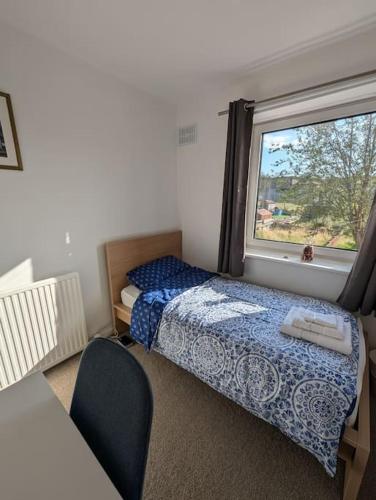 a small bedroom with a bed and a window at Lovely 3-Bed Edinburgh Flat in Edinburgh