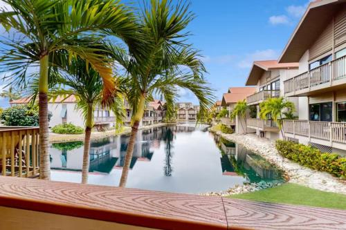 a pool at a resort with palm trees and condos at Our House at the Lake House C117 by Beachside in Siesta Key