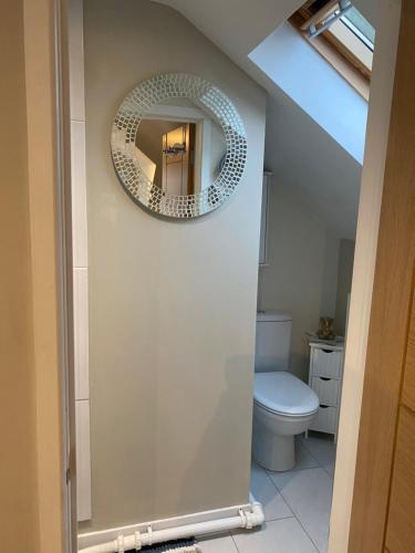 a bathroom with a toilet and a mirror on the wall at Wendys house in Sarisbury Green