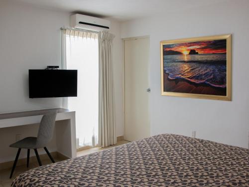 a bedroom with a bed and a television and a window at Hotel St. George in Celaya
