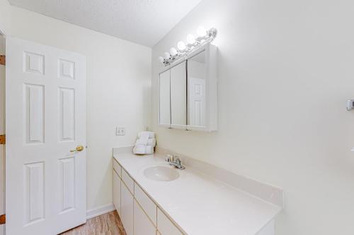 a white bathroom with a sink and a mirror at Seascape in Myrtle Beach