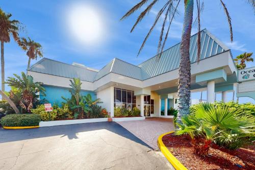 a house with palm trees in front of it at Ocean Breeze Retreat in Daytona Beach
