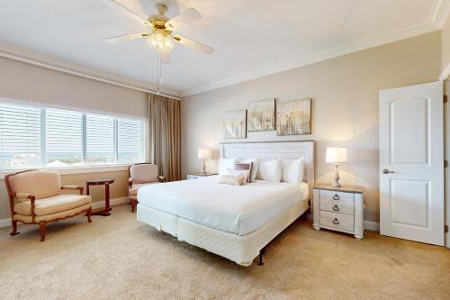 Un dormitorio con una cama y un ventilador de techo. en Dolphin Point 702A, en Destin