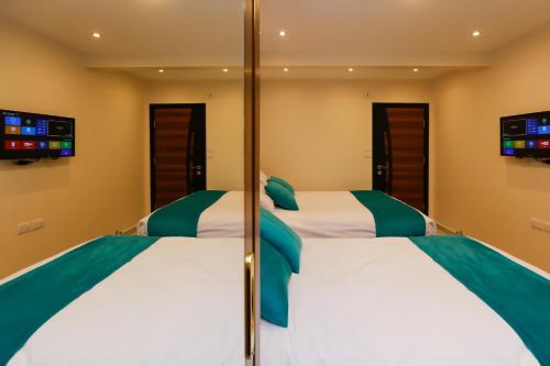 two beds in a hotel room with mirrors at Diamond Pyramids View Inn in Cairo