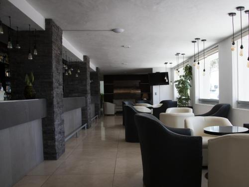 a restaurant with black and white chairs and tables at Hotel St. George in Celaya