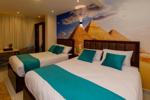 2 letti in una camera d'albergo con un dipinto sul muro di Diamond Pyramids View Inn a Il Cairo
