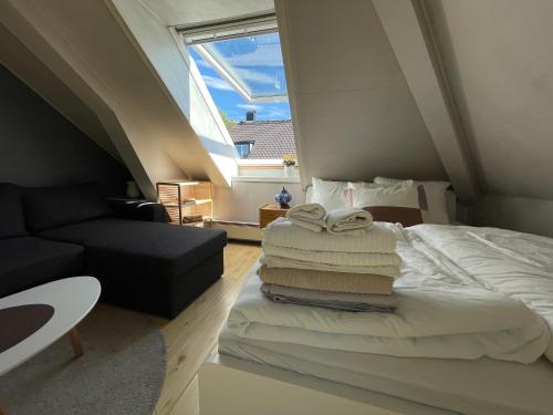 a bedroom with a bed with a stack of towels at City View & Central Location in Trondheim
