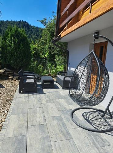 a patio with a swing and a picnic table at Agroturystyka Oblica in Zawoja