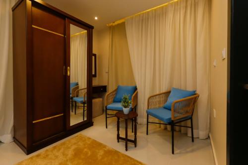 a hotel room with blue chairs and a mirror at Diamond Pyramids View Inn in Cairo