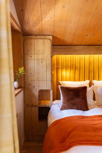 une chambre avec un grand lit avec une tête de lit en bois dans l'établissement Three Bedroom Chalet Lemon Pit Chamonix, à Chamonix-Mont-Blanc