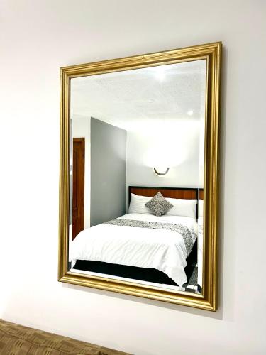 a mirror on a wall with a bed in it at ACCEL Hotel La Quinta in Ibarra