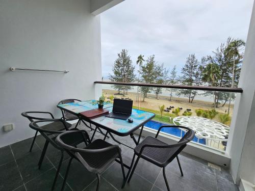 a room with a table with chairs and a laptop on it at Kenyalang Roxy Sematan Homestay in Sematan