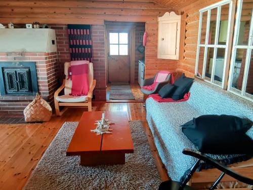 a living room with a couch and chairs and a fireplace at Velkuanmaa Lomamökki in Naantali