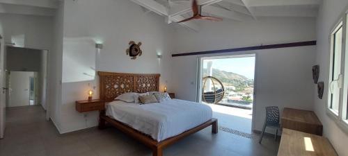 a bedroom with a bed and a large window at Villa Vénus Amazing view in Cul de Sac