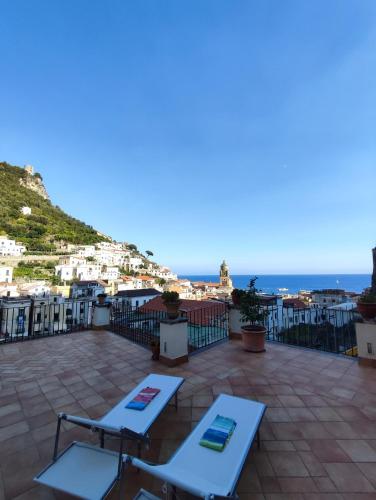 a view of a patio with chairs and the ocean at #goldenhour in Amalfi
