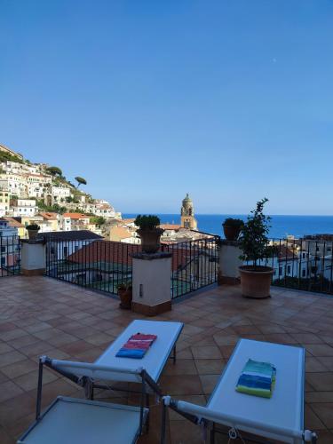 a patio with two lounge chairs and the ocean at #goldenhour in Amalfi