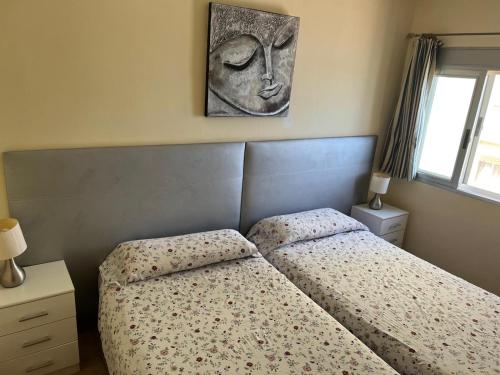a bedroom with two beds and a picture on the wall at Apartamento Rey I in Valencia