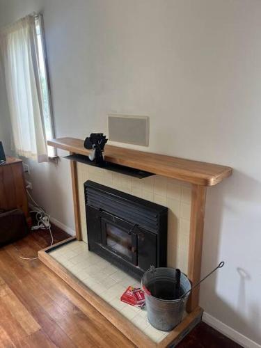 a living room with a fireplace with a microwave at Greytown Farmhouse in Greytown