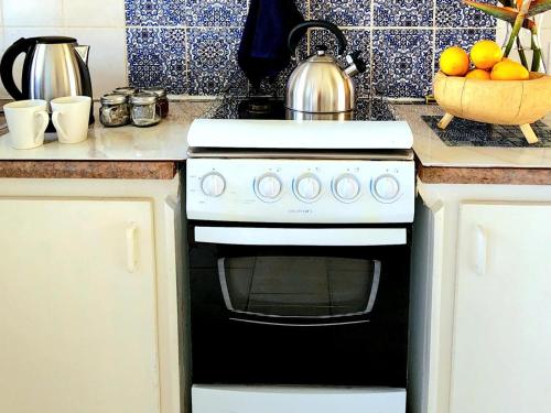 a kitchen stove with a tea kettle on top of it at The Barn at Tembele in Dalmada AH