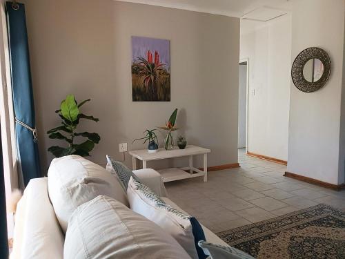 a living room with a white couch and a table at The Barn at Tembele in Dalmada AH