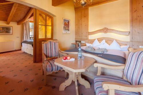 a bedroom with a bed and a table and chairs at Sporthotel Schönruh in Ehrwald