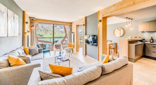 Il comprend un salon avec un grand canapé et une cuisine. dans l'établissement Résidence Phoenix - 5 Pièces pour 8 Personnes MAE-4411, à Tignes