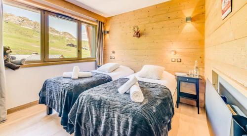 deux lits dans une chambre avec une fenêtre dans l'établissement Résidence Phoenix - 5 Pièces pour 8 Personnes MAE-4411, à Tignes