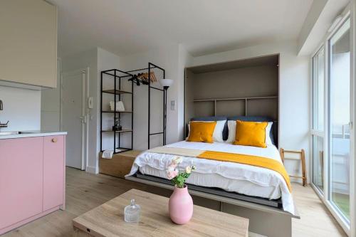 - une chambre avec un grand lit et un vase sur une table dans l'établissement Appartement cosy à Paris, à Puteaux