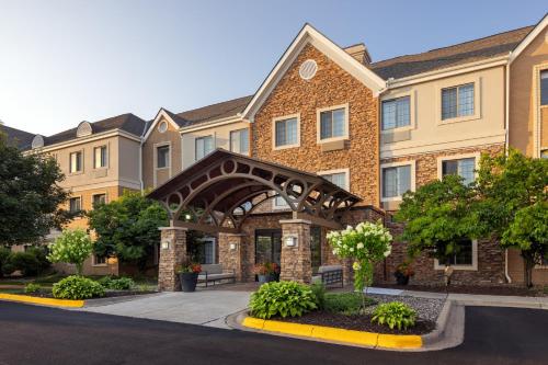 a large brick building with an arched entry way at Staybridge Suites Minneapolis-Maple Grove by IHG in Maple Grove