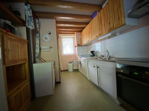une petite cuisine avec un évier et une cuisinière dans l'établissement Grand duplex avec 3 chambres à deux pas de Saint-Lary, à Vielle-Aure