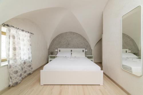 a white bed in a room with a mirror at Comfort Zone - Amalfi Coast in Maiori
