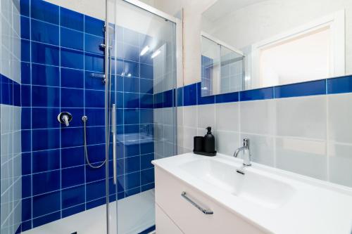 a blue tiled bathroom with a sink and a shower at Comfort Zone - Amalfi Coast in Maiori