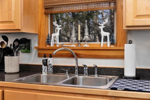 un lavello da cucina con statuette di cervi su una finestra di Wintergreen Springjacuzzifirepitpool Access a Roseland