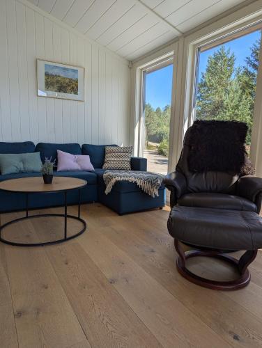 a living room with a blue couch and a table at Bjønntjønn 229 in Heimdal