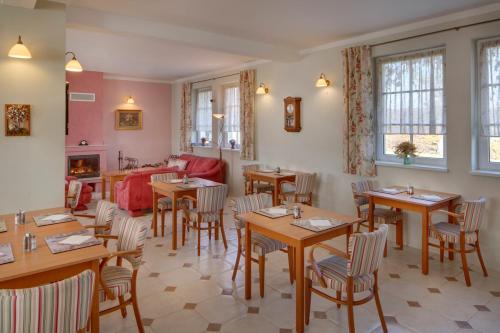 a restaurant with tables and chairs and a couch at Hotel Kolonie in Křivoklát