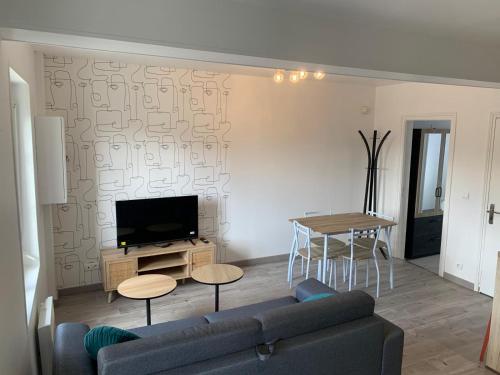 un salon avec un canapé et une table dans l'établissement Les Nids Douillets, à Saint-Laurent-en-Caux