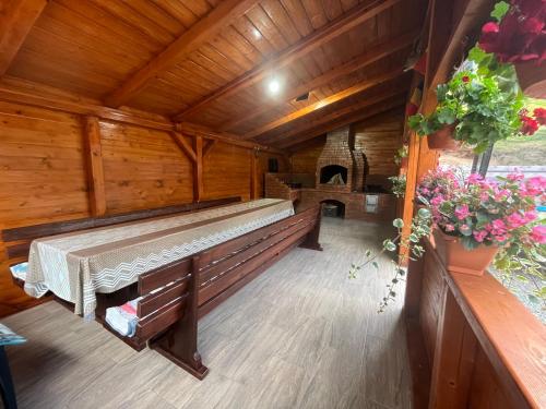 an empty bench in a wooden room with a fireplace at Cabana Lazea in Gîrda de Sus