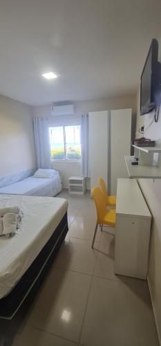 um quarto com uma cama, uma escrivaninha e uma televisão em Marinas de Tamandaré 102 em Tamandaré