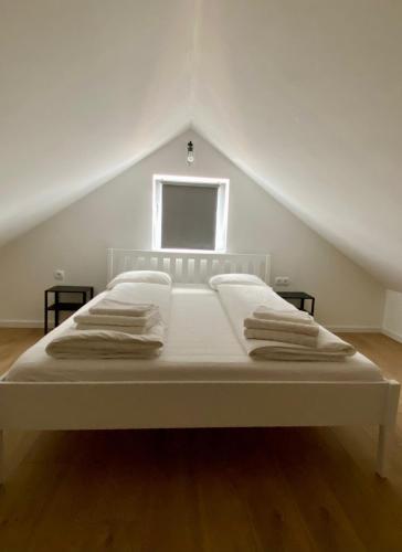 a white bed in a attic with a window at Antiva in Livno
