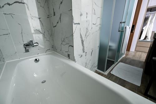 a white bath tub in a bathroom with a shower at OOD Hotel Taipei HangZhou in Taipei